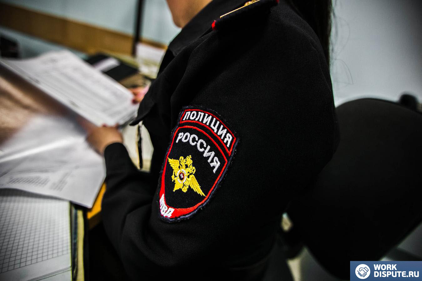 полицейский держит в руках документы